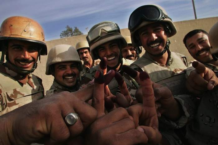Iraqi soldiers cheer showing ink-stained fingers after casting their vote at a polling station in Baghdad during the 2005 election.Photo by Maurico Lima\/AFP\/Getty Images