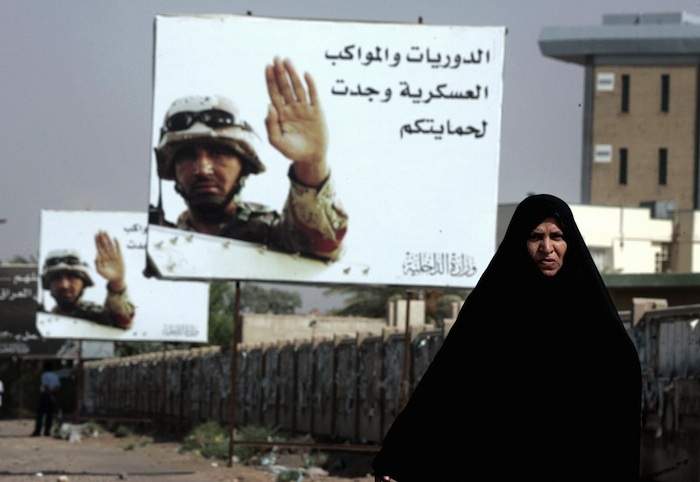 An Iraqi woman walks past billboards reading 'Patrols and military convoys are for your protection' in Baghdad in August 2006.
Photo by Karim Sahib/AFP/Getty Images